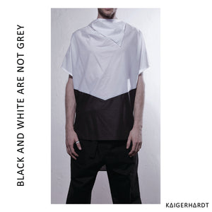 Man wears a white and black draped t-shirt which is which is horizontally separated into black and white this give the shirt its special arrow look. He also a wears black trousers and a white enemal ring at his right thumb.