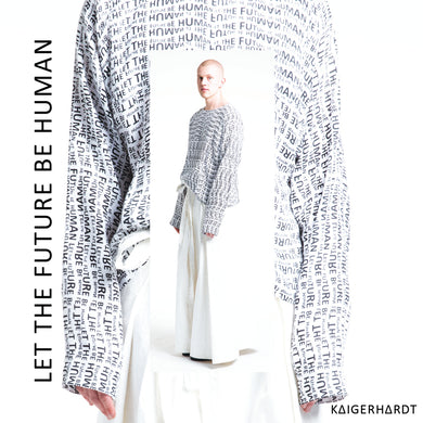 Paulius is wearing a white light sweater which has an all over print in small letters which says let the future be human. The sweater has long sleeves so that you only see the finger tips of the model. withe the sweater he wears a white long wide pair of trousers in hakama style made out of denim. 
