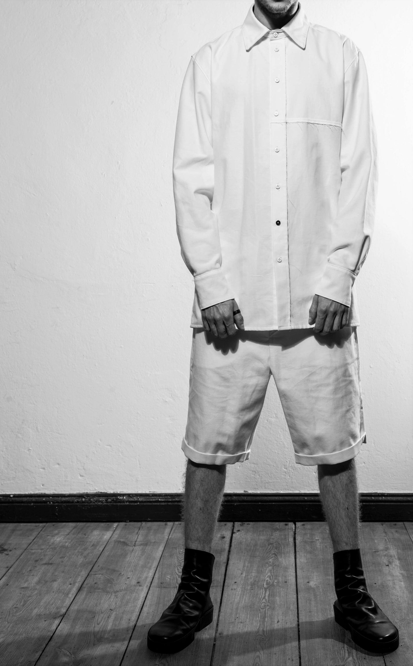 A classic shirt with raw-edges at the yoke in the back and the left side at the front, the inner layer are white at the cuffs, yoke and stand. The shirt is made in Berlin Germany.        Colour: white, black Material: 90% cotton, 10% linen